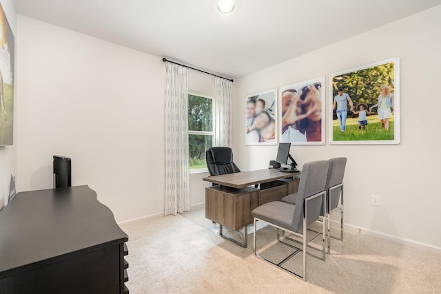 office space featuring light carpet and baseboards