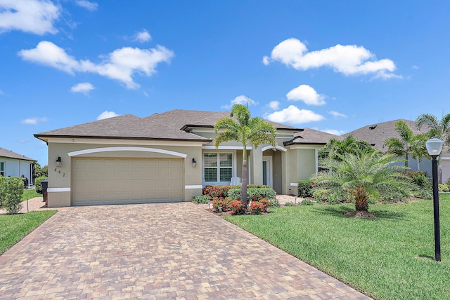 view of front of property with a garage, decorative driveway, a front yard, and stucco siding