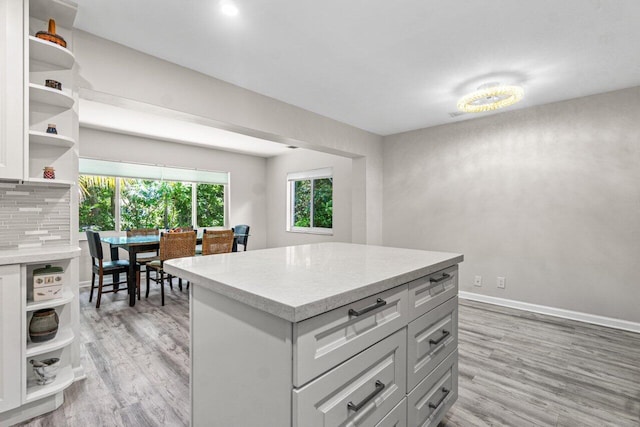 kitchen featuring backsplash, light hardwood / wood-style floors, and a kitchen island