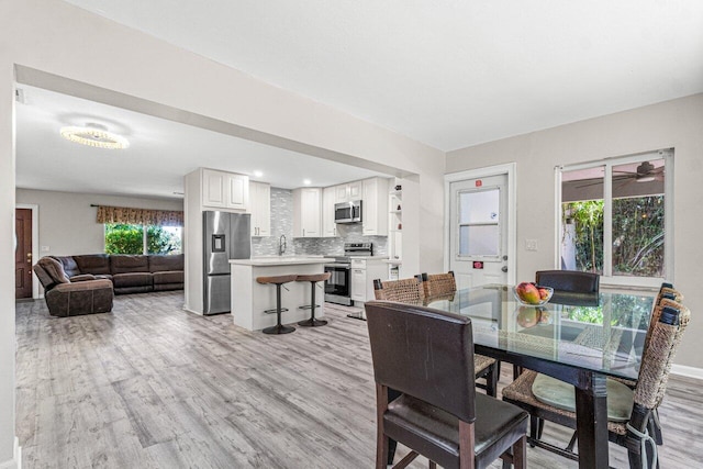 dining space featuring light hardwood / wood-style flooring and sink