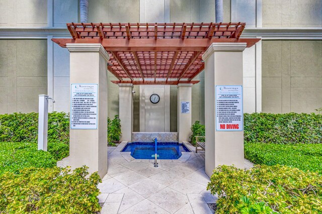 property entrance featuring a pergola and stucco siding