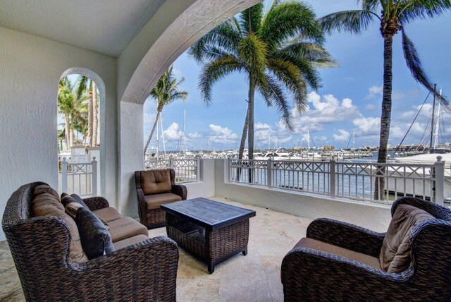 view of patio with an outdoor living space, a water view, and a balcony