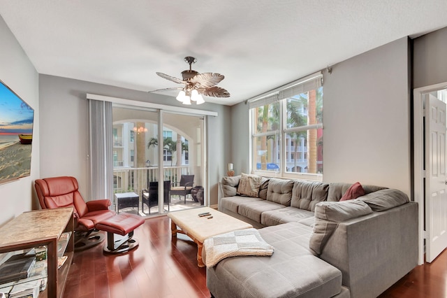 living room with ceiling fan with notable chandelier and wood finished floors