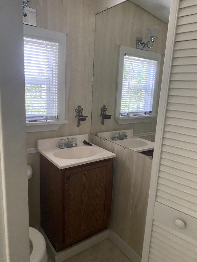 bathroom featuring toilet, plenty of natural light, and vanity