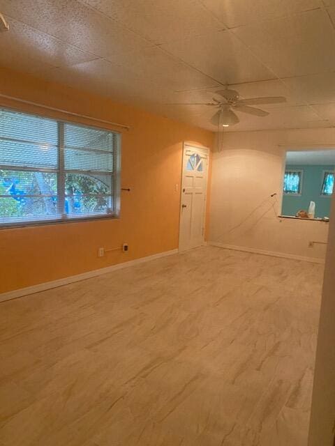 interior space featuring baseboards and a ceiling fan