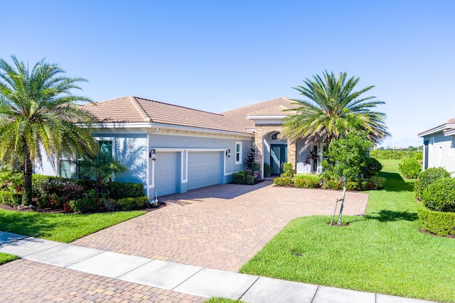 view of front of property with a front yard and a garage