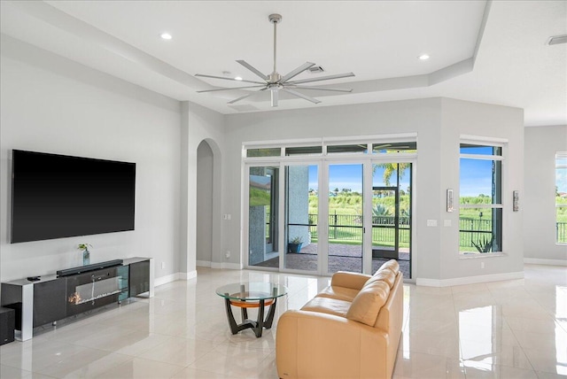 living room with a fireplace, baseboards, arched walkways, and recessed lighting