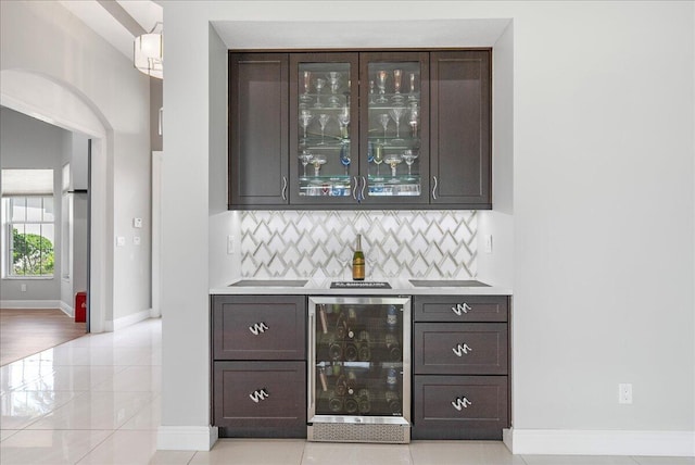 bar with a bar, tasteful backsplash, wine cooler, and baseboards