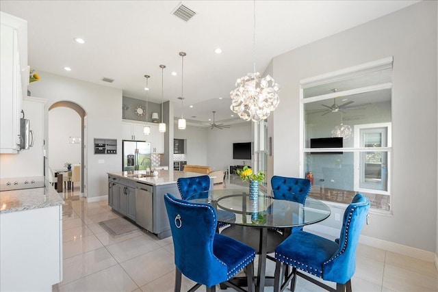 dining area with arched walkways, ceiling fan with notable chandelier, visible vents, and recessed lighting