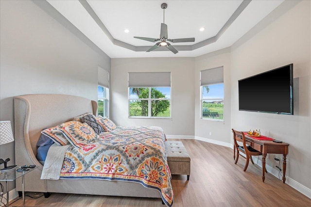 bedroom featuring baseboards, a raised ceiling, ceiling fan, wood finished floors, and recessed lighting