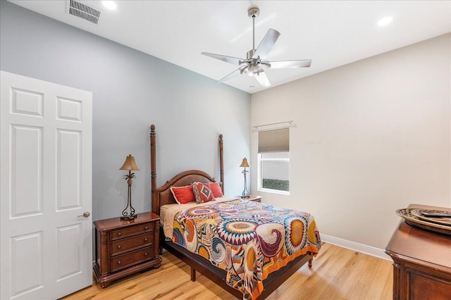 bedroom with ceiling fan, light wood-type flooring, visible vents, and baseboards