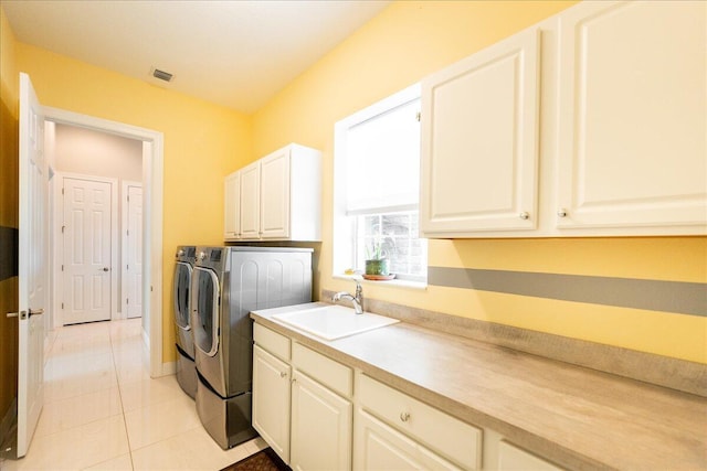 washroom featuring light tile patterned flooring, separate washer and dryer, a sink, baseboards, and cabinet space