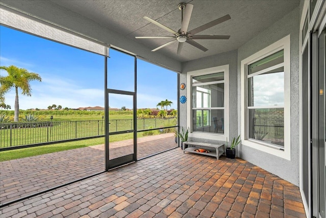 unfurnished sunroom with ceiling fan