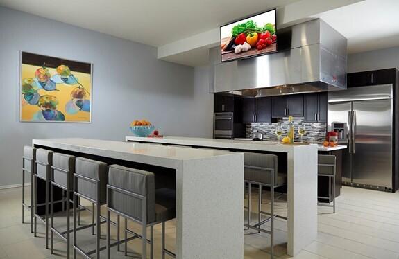 kitchen with stainless steel appliances, light countertops, decorative backsplash, and wall chimney exhaust hood