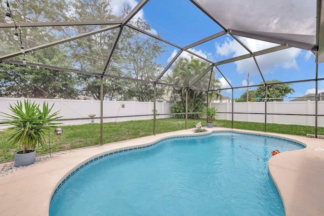 view of pool with a lanai and a yard