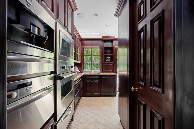 kitchen with open shelves, appliances with stainless steel finishes, light countertops, and crown molding