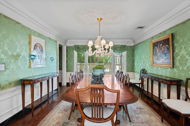 dining area with an inviting chandelier, ornamental molding, wainscoting, wood finished floors, and wallpapered walls