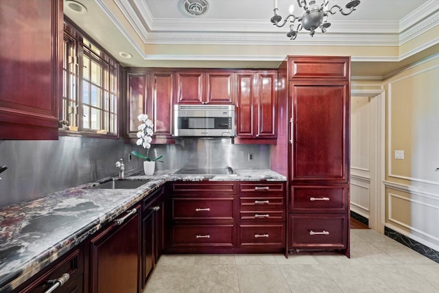 kitchen with reddish brown cabinets, visible vents, dark stone counters, stainless steel microwave, and a sink