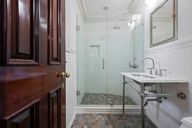 full bath featuring a sink, a stall shower, tile walls, and crown molding