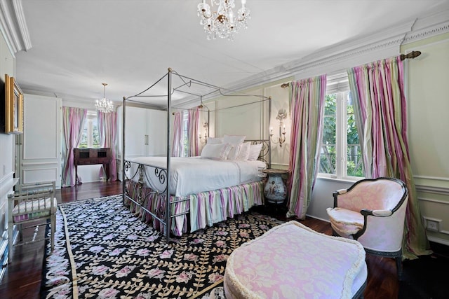 bedroom featuring a chandelier, dark wood finished floors, and ornamental molding