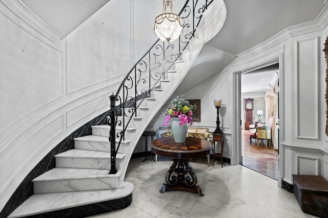 staircase with ornamental molding and a decorative wall