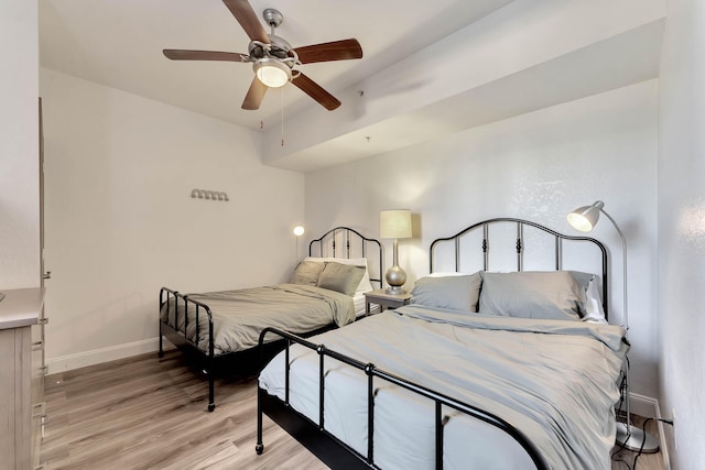 bedroom with light wood-style flooring, baseboards, and ceiling fan