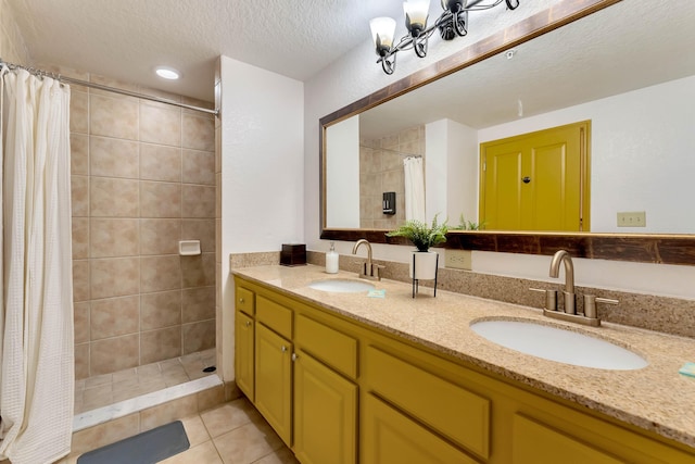 bathroom with a textured ceiling, double vanity, a sink, and a shower stall