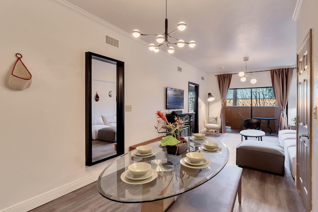 dining room featuring crown molding, a chandelier, and wood-type flooring