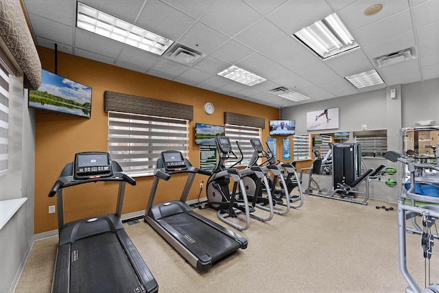 exercise room featuring a paneled ceiling, baseboards, and visible vents