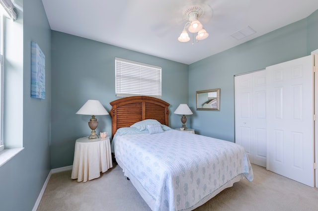 carpeted bedroom with ceiling fan and a closet