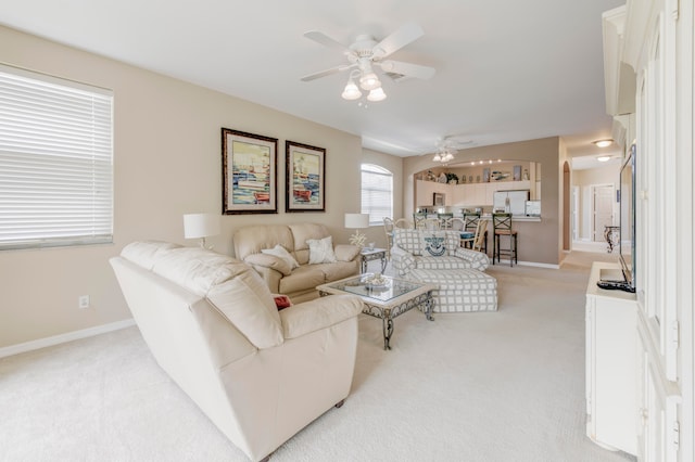 carpeted living room with ceiling fan