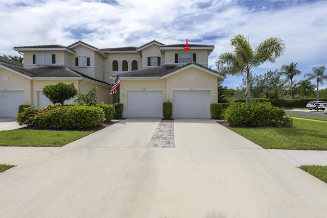 view of front of property featuring a garage, concrete driveway, a tiled roof, and stucco siding