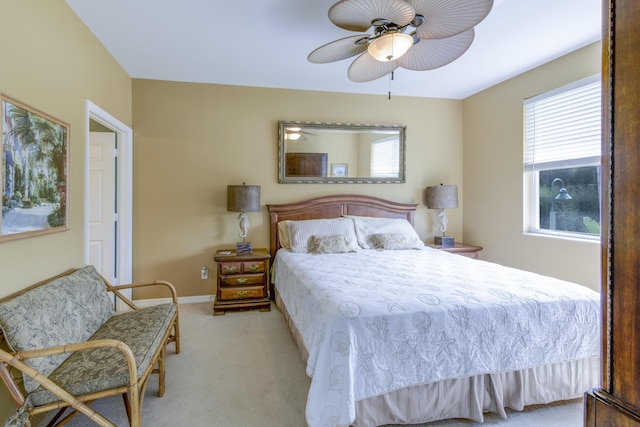 bedroom featuring light carpet, a ceiling fan, and baseboards