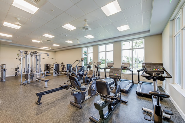 exercise room featuring a healthy amount of sunlight, baseboards, visible vents, and a paneled ceiling
