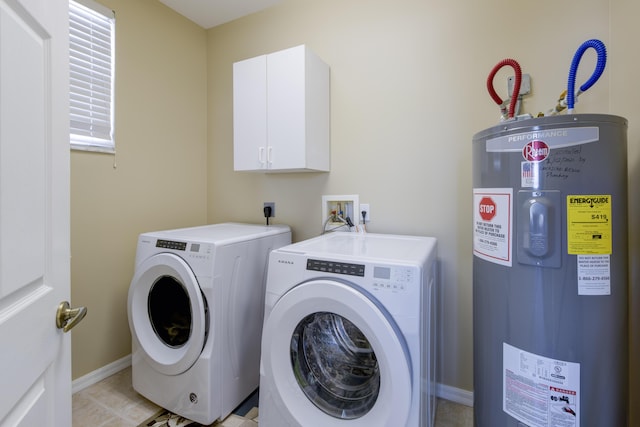 clothes washing area featuring cabinet space, water heater, baseboards, and separate washer and dryer