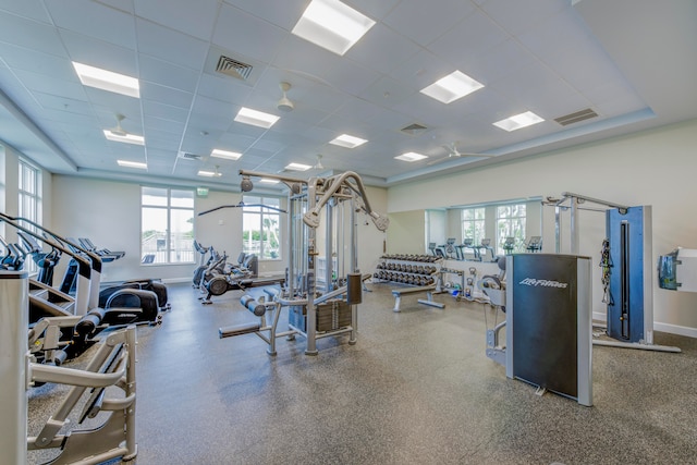 gym with a paneled ceiling and a healthy amount of sunlight