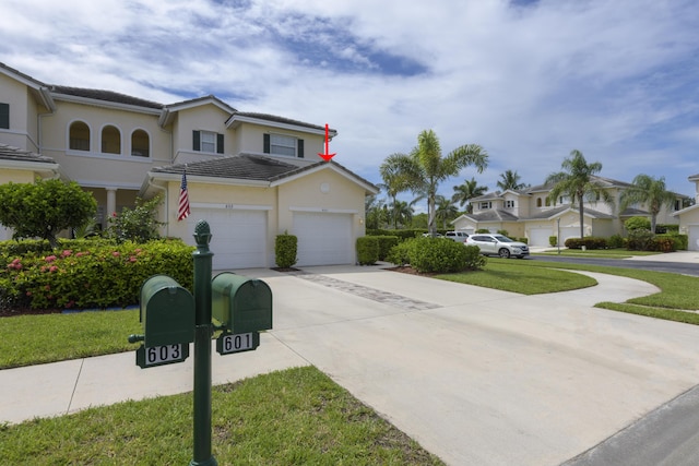 exterior space with an attached garage, driveway, a tiled roof, a residential view, and stucco siding