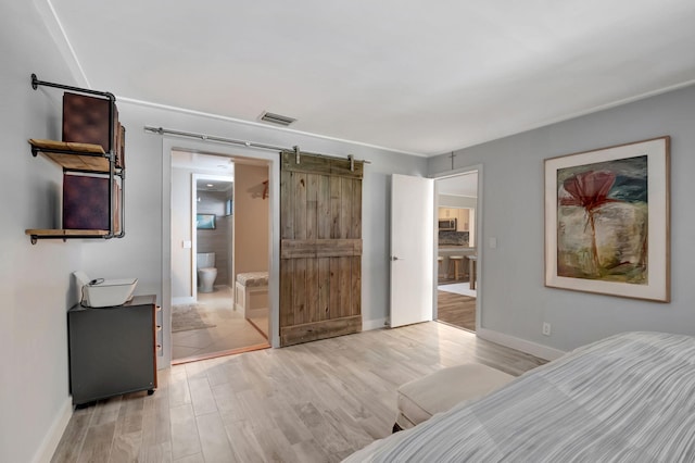 tiled bedroom featuring a barn door and ensuite bath