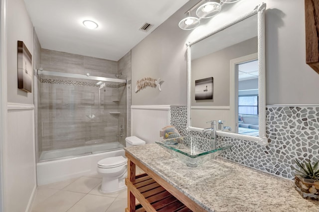 full bathroom with tiled shower / bath, tile flooring, oversized vanity, and toilet