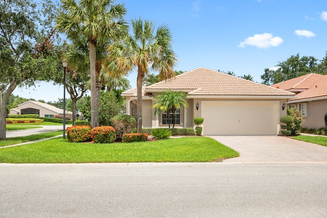 mediterranean / spanish-style house with a garage and a front yard