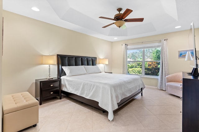 tiled bedroom featuring a raised ceiling and ceiling fan