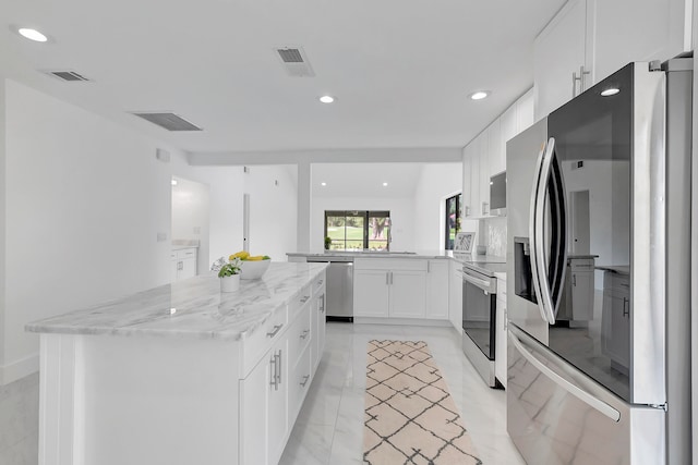 kitchen featuring white cabinetry, light stone countertops, stainless steel appliances, kitchen peninsula, and light tile floors