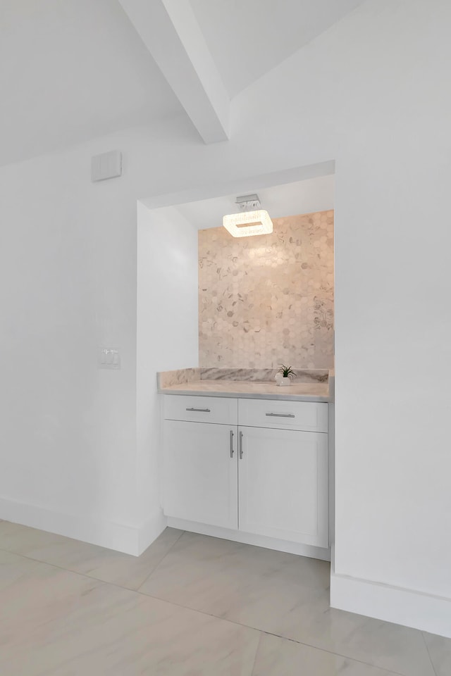 bar featuring white cabinets, tasteful backsplash, and light tile floors