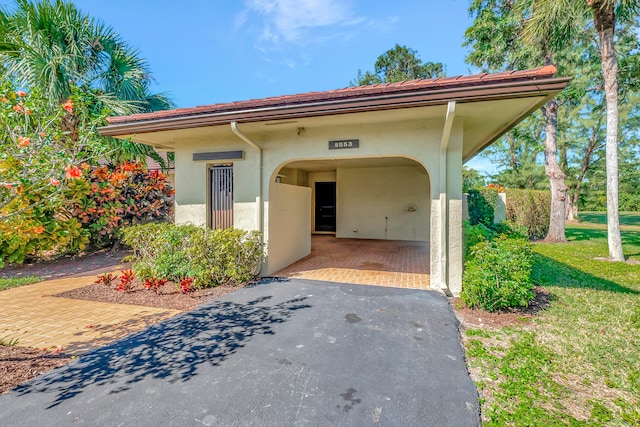 mediterranean / spanish-style house with a carport and a front yard