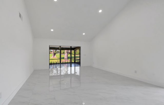 empty room with lofted ceiling and light tile floors