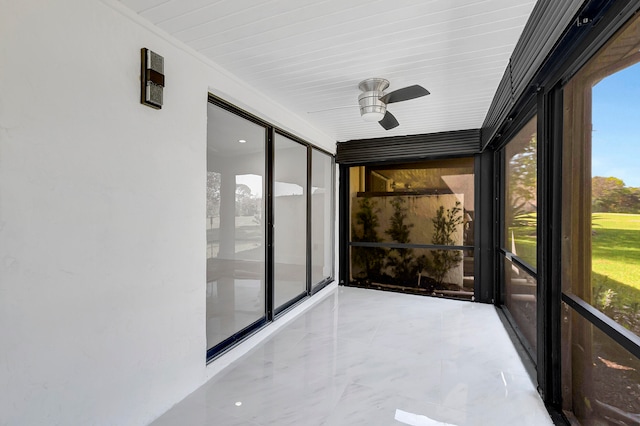 unfurnished sunroom with ceiling fan