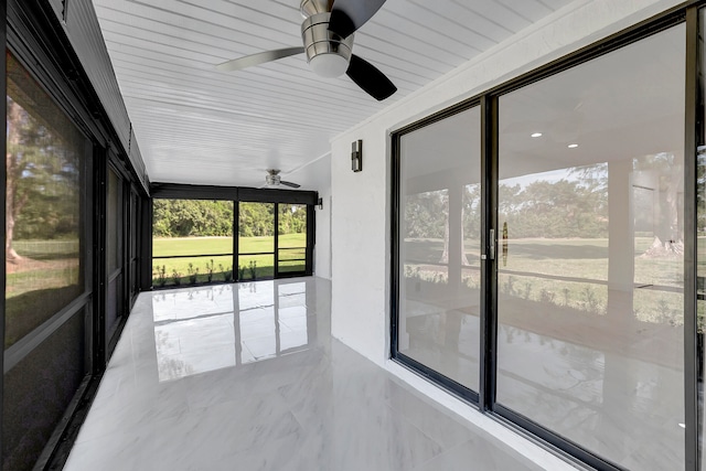 unfurnished sunroom with ceiling fan