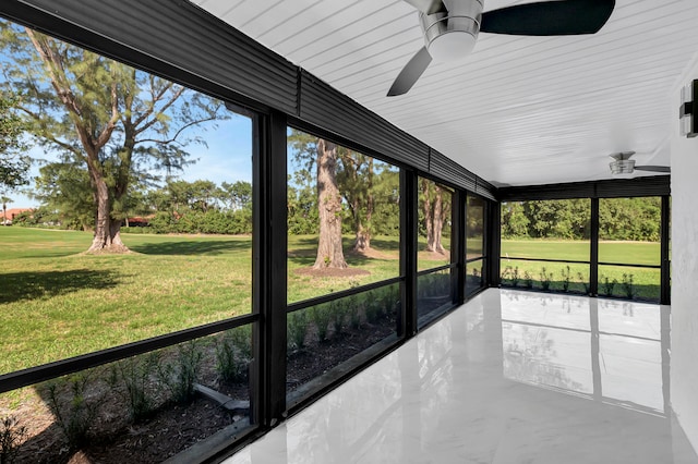 unfurnished sunroom featuring a wealth of natural light and ceiling fan