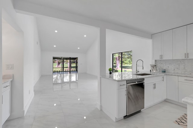 kitchen featuring dishwasher, white cabinetry, light tile flooring, and kitchen peninsula