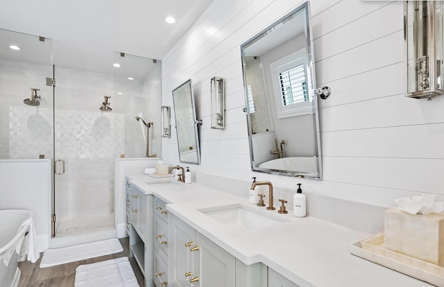 bathroom with shower with separate bathtub, vanity, and wood-type flooring